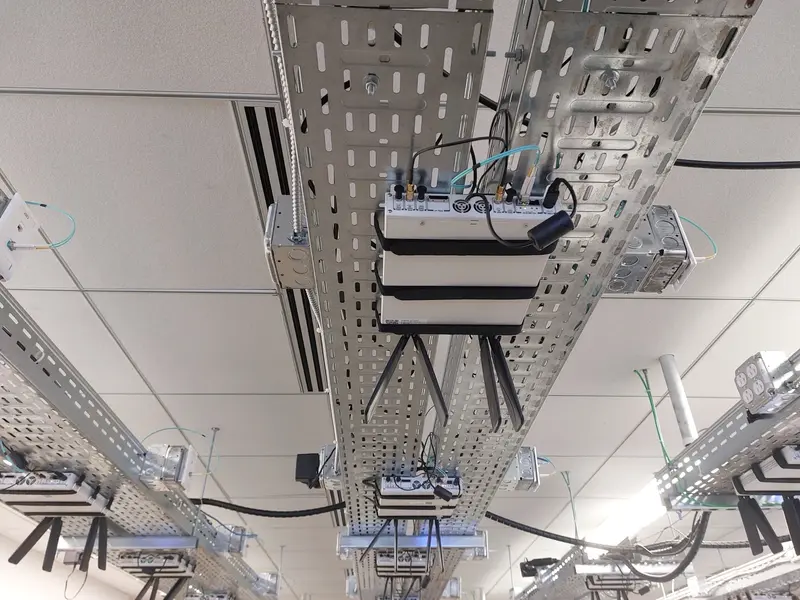 Radio units mounted on cable trays under the lab ceiling